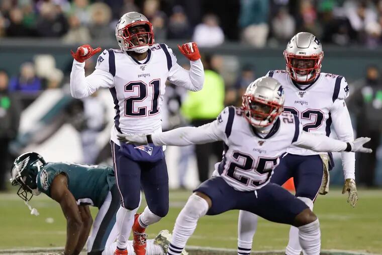 New England Patriots defensive backs Duron Harmon (21), Terrence Brooks (25) and Devin McCourty celebrate after a stop on Eagles wide receiver Nelson Agholor during the fourth-quarter on Sunday.