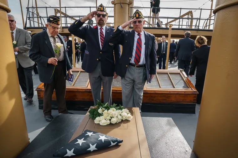 On board the USS Olympia Veterans Andy Waskie, center, and Craig Nesbitt salute salute during a recent ceremony after placing roses on the historical marker for the Unknown Soldier, which marks the spot where the Navy placed the casket on the cruiser 100 years ago. Holding a white rose to the left is veteran Edwin Berna.