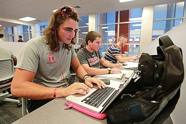 Temple students Charles Anderson, Michael Ryan Dartnell and Anderson Grochoski do homework as Temple unveils improvements to the Nancy and Donald Resnick Academic Support Center (David Swanson/Staff Photographer)