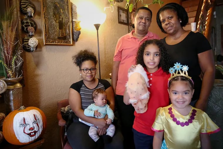 Ramon Garcia, center rear, and his wife, Kathy Soler, rear right, stand for a portrait with their daughter Kathy Garcia, far left; son Dominick Garcia, 10, front center; and Kathy Garcia's daughters, 3-month-old Kaydrianie Garcia, second from left; and Kaylanie Reyes, 6, front right, at their home in Philadelphia's Kensington section on Wednesday, Oct. 23, 2019. The family lives on the block where 2-year-old Nikolette Rivera was shot and killed Sunday. For the last couple of years, they have gone trick-or-treating in a different neighborhood due to safety concerns.