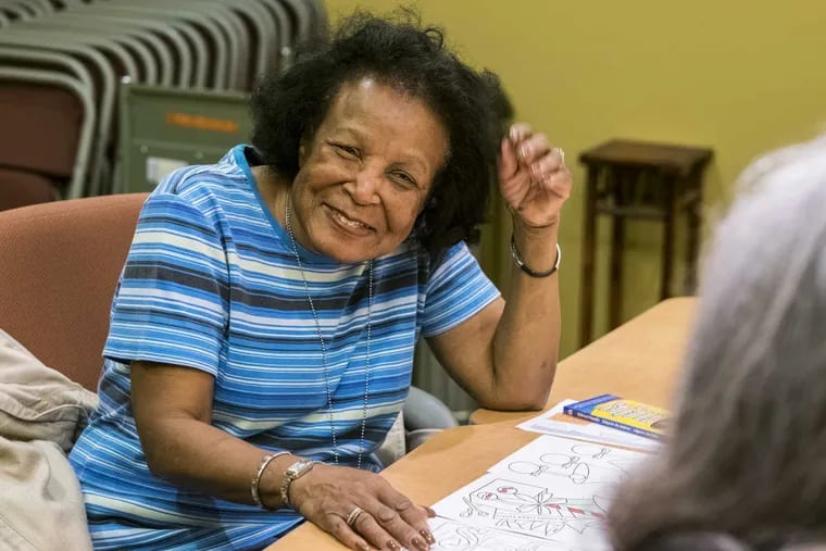 Demetra Evans, 78, pauses from her coloring at the Cherry Hill Library to socialize with another participant.