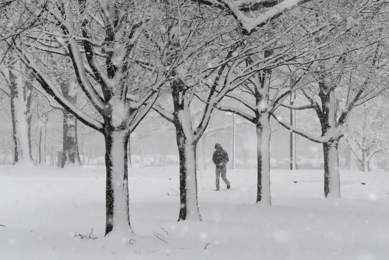 A man walks through the snow during a March storm; winter is refusing to go away.