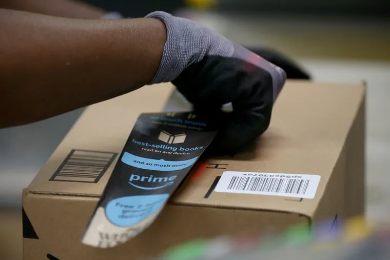 A worker boxes up an order to be shipped at the Amazon Fulfillment Center in West Deptford, N.J.
