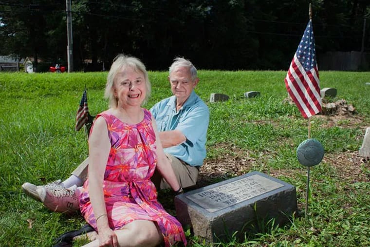 Christina and Dwight McCawley at the gravesite of the artist Horace Pippin. When the couple saw that the grave had been neglected, they took it upon themselves to clean it up.