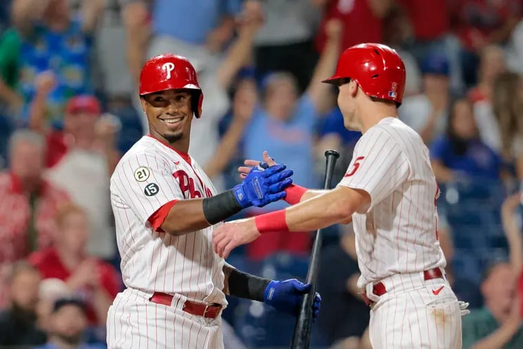 Phillies catcher Andrew Knapp (right) is greeted by Jean Segura after scoring the winning run on a passed ball in the ninth.