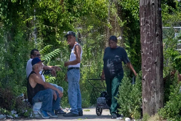 Three men take shelter from the heat on the shady side of the 500 block of Susquehanna in North Philadelphia on a hot Monday.