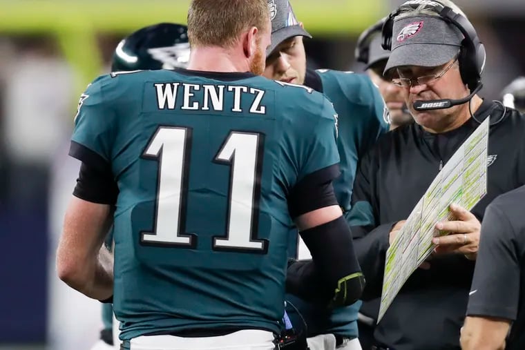 Eagles head coach Doug Pederson looks over the play chart with quarterback Carson Wentz during the third-quarter against the Dallas Cowboys on Sunday, October 20, 2019 in Arlington, TX.
