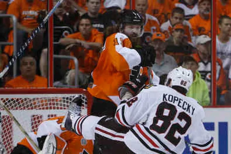 The Blackhawks' Tomas Kopecky goes sprawling to the ice, thanks to a hit by Scott Hartnell in the second period of Game 3.