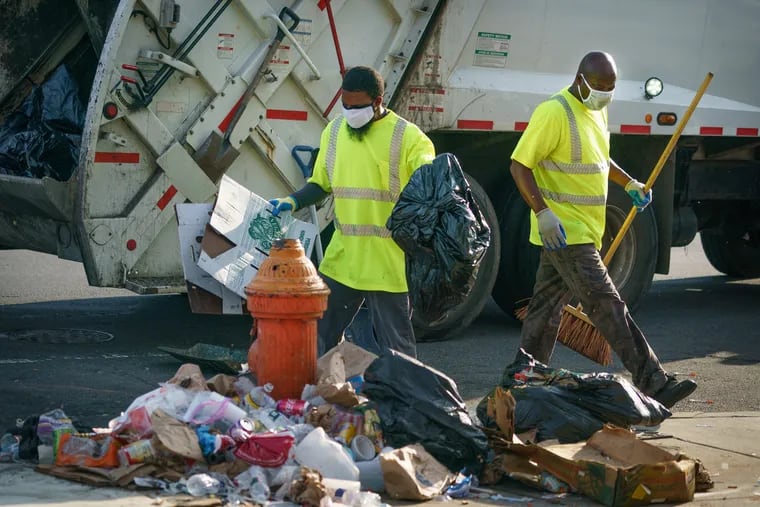 Sanitation workers collect trash on East Allegheny Avenue last year.