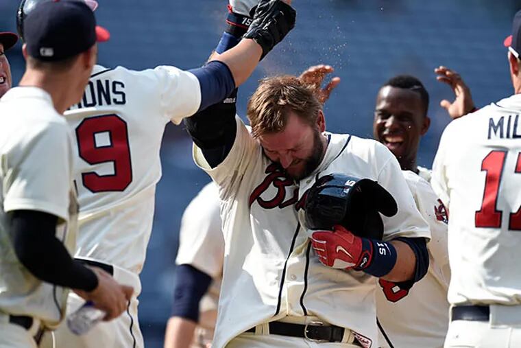 Atlanta Braves catcher A.J. Pierzynski (15) reacts with teammates after driving in the winning run against the Philadelphia Phillies during the ninth inning at Turner Field. The Braves defeated the Phillies 2-1.
