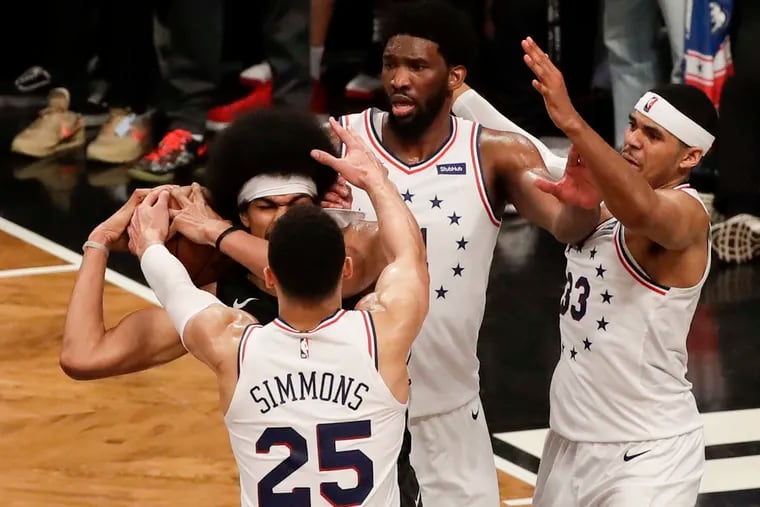 With Joel Embiid and Tobias Harris defending, Ben Simmons strips the ball away from Brooklyn's Jarrett Allen late in the fourth quarter of the Sixers' playoff win on Saturday.