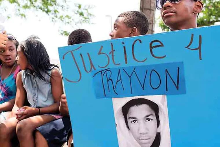 Tymere Barton, 15, from Camden, (right) holds a sign for Trayvon Martin at a rally at city hall in Camden on July 19.  A march and rally were held in Camden to protest the verdict of the George Zimmerman trial which was reached earlier in the week.  ( ANDREW RENNEISEN / Staff Photographer )