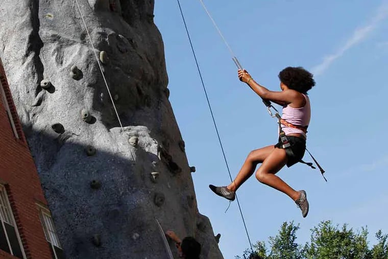 Gelisa Dukes, 10, rappels down after making it to the top of a climbing wall on South Street. Philly Greenfest returns in Headhouse Square with 100 plus exhibitors, eco activities, entertainment, and food on Sunday, September 7 2014. ( MICHAEL S. WIRTZ / Staff Photographer ).