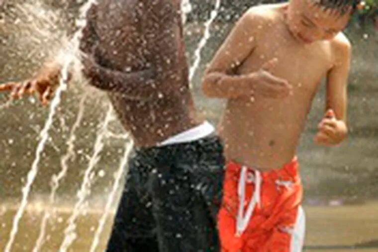 While school district officials yesterday made plans for next year&#0039;s curriculum, these children play in the water in a West Philadelphia park.