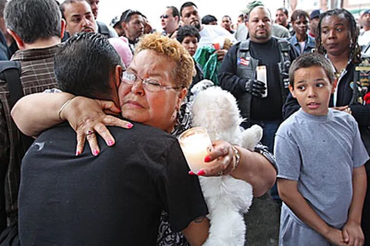 Elsa Rosario, the grandmother of Gina Marie Rosario, 7, who died Wednesday night, receives a hug from a family member during a memorial service for the four victims who died in the Feltonville section fo Philadelphia. ( Michael Bryant / Staff Photographer )