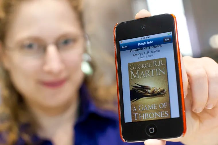 Dena Heilik, department head of Philbrick Hall at the Free Library, holds an ebook copy of “A Game of Thrones.”