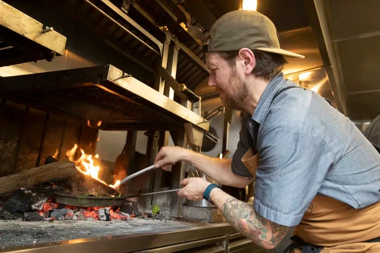 Scott Calhoun, chef and co-owner of Ember & Ash, cooks charred rabe at the East Passyunk restaurant. “This industry is tough,” he said. “It’s hard to work in, it’s hard on people emotionally, mentally, and physically, and it requires long hours that most people couldn’t even fathom as a way of life.”