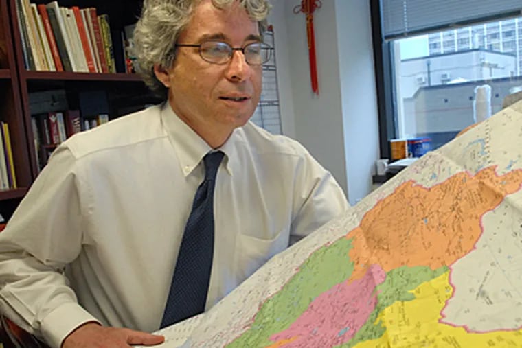 Dr. David Metzger of the University of Pennsylvania with map of China where he will spend two weeks research AIDS for a project. (Peter Tobia / Inquirer)