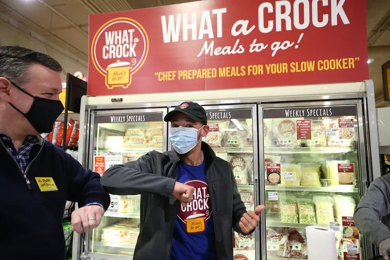 ShopRite owner Jeff Brown (left) bumps elbows with NaKwai DeShields (right), an owner of What a Crock, inside the Cheltenham ShopRite supermarket in Wyncote, Pa., on March 22, 2021. DeShields was offering product samples to customers.