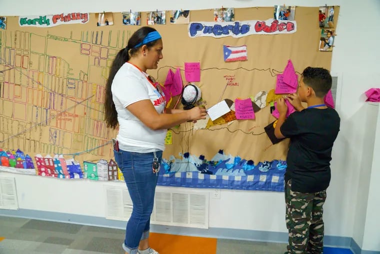 Charito Morales, left, shown here with Yandel Rodriguez, right, and a large map Charito created to help kids who had moved from Puerto Rico to Philadelphia, at Providence Center, in Philadelphia, Monday, August 6, 2018. JESSICA GRIFFIN / Staff Photographer