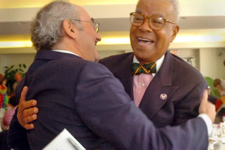 Chuck Stone (right) greets former Daily News editor Zack Stalberg during a reception at the Free Library in 2004. (G.W. MILLER III / FILE PHOTO)