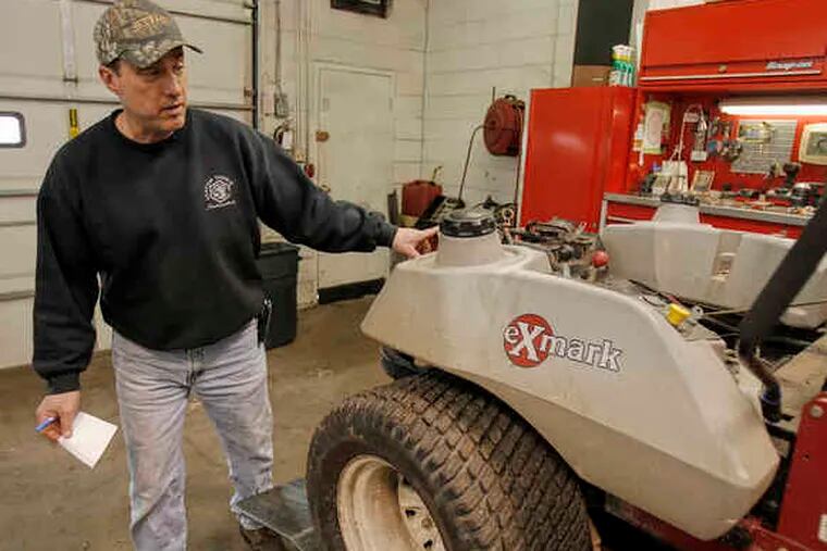 Robert Jones of R.J. Power Equipment checks over a broken commercial lawn mower than needs to be repaired. Before the recession, the owner would likely have bought a new one.