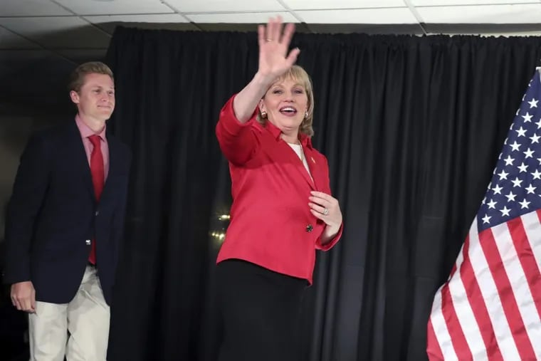 New Jersey Republican Lt. Gov. Kim Guadagno is followed by her son, Michael, as she takes the stage at her primary election night event.