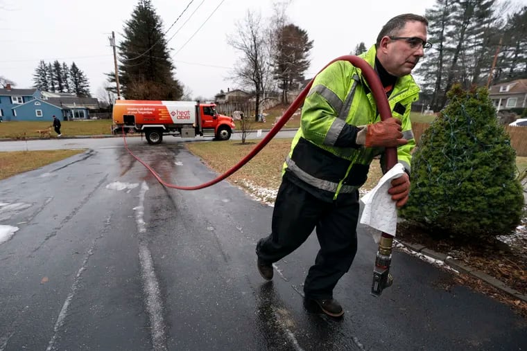 A heating oil delivery man hauling a hose up the driveway of a Maine home last winter. It will cost 45% more to heat a home with fuel oil in America this winter, according to the U.S. Department of Energy.