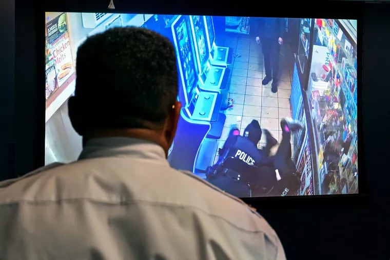 Philadelphia Police Commissioner Kevin Bethel watches video at a news conference Tuesday showing the Fairhill shooting that left an officer wounded and a suspect dead.