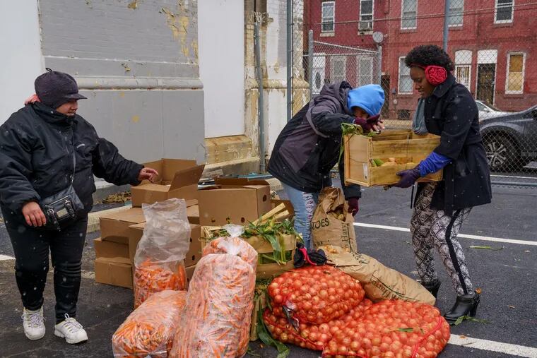 Volunteers outside the Lillian Marrero branch of  the Free Library of Philadelphia distribute food supplied by Philabundance's Fresh For All program to residents in Fairhill.