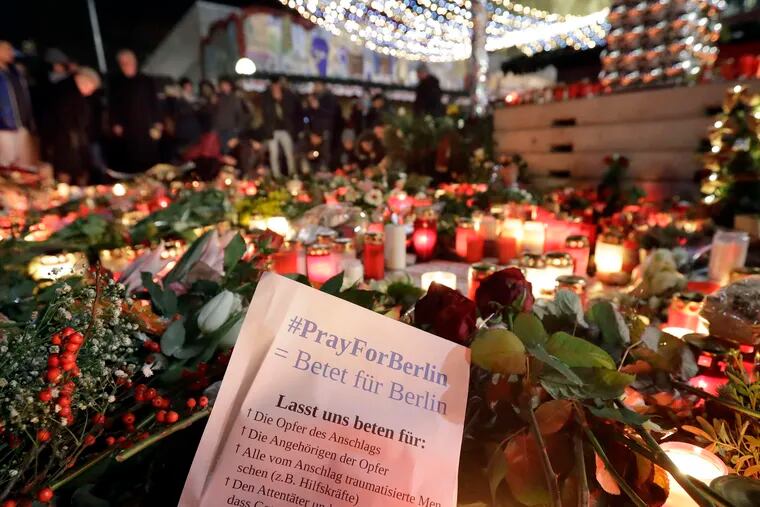 People gather at a memorial to victims of the Berlin truck attack. News that the man sought in the attack had been on authorities' radar for months and been denied asylum added to the anger and pain in Germany.