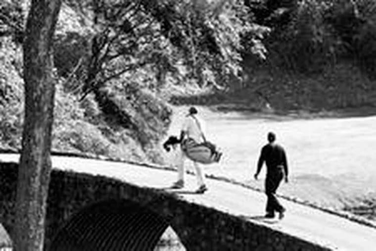 Tiger Woods and his caddie, Steve Williams, cross the Hogan Bridge to the 12th green at Amen Corner, the celebrated 12th and 13th holes at Augusta National.
