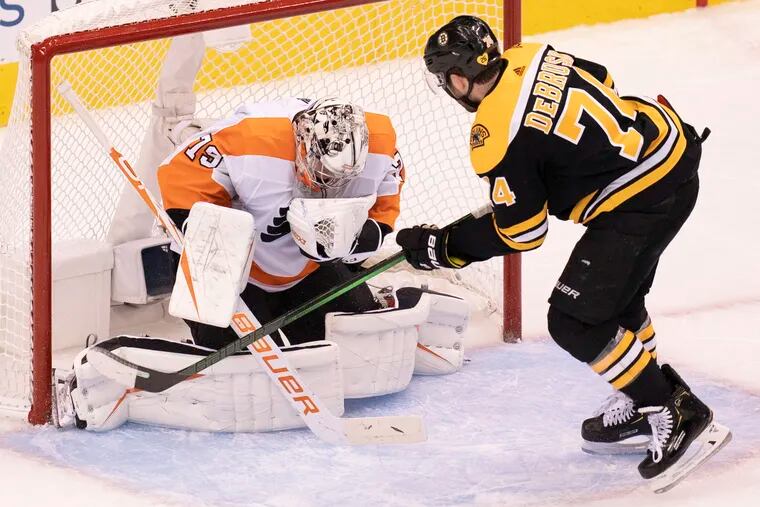 Flyers goaltender Carter Hart (79) makes a save against Boston Bruins left wing Jake DeBrusk (74) during the first period.