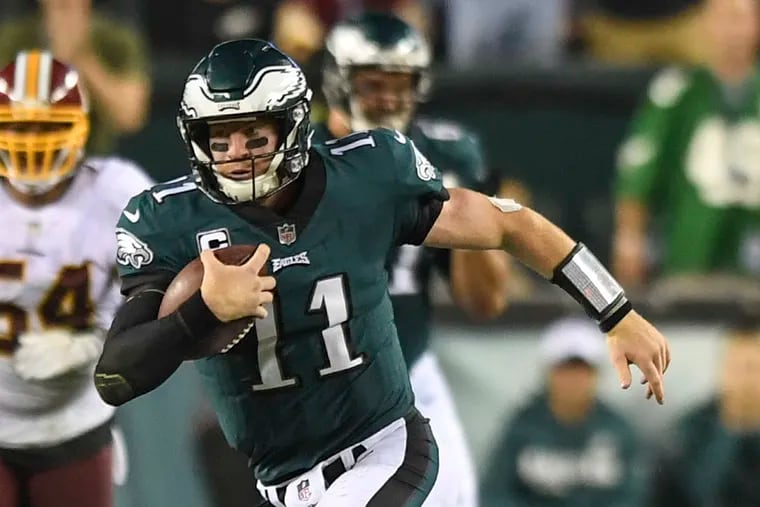 Philadelphia Eagles quarterback Carson Wentz escapes the scrum for 17 yards and a first down in the 4th quarter against the Washington Redskins at Lincoln Financial Field.