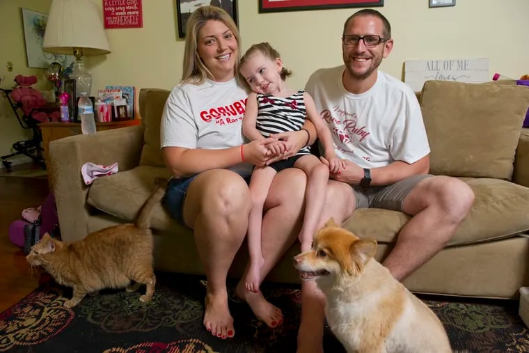 Mindy and David Hoffman hold their daughter Ruby, 4, in their York, PA home.