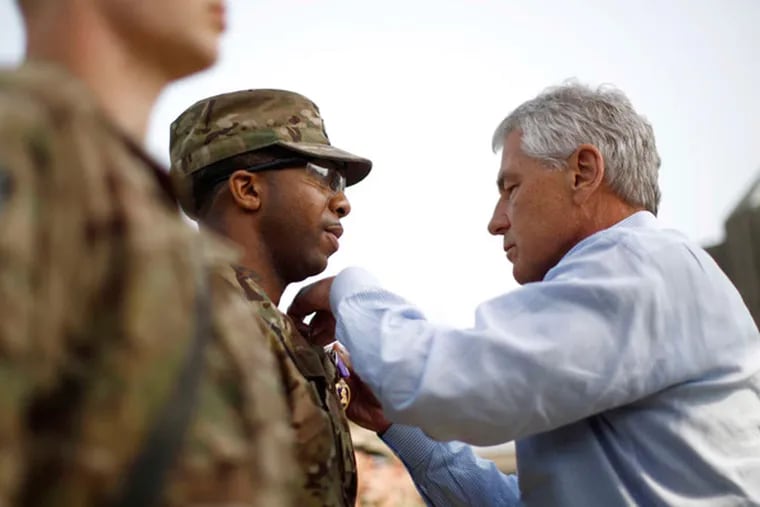 Defense Secretary Chuck Hagel participates in the awarding of a Purple Heart to Sgt. Jeremyah Williams of the 426th Brigade Support Battalion, at Jalalabad Airfield in eastern Afghanistan. (Associated Press)
