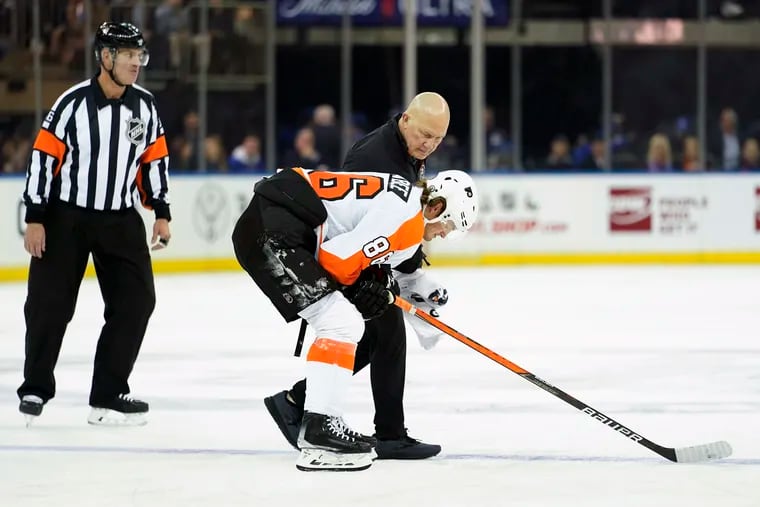 Flyers left winger Joel Farabee is escorted off the ice by trainer Jim McCrossin after being injured during the first period Wednesday at Madison Square Garden. Farabee did not return in the Rangers' 4-1 win.
