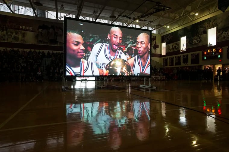 A video tribute to Kobe Bryant is played. This image shows Kobe and the Lower Merion team with the Pennsylvania state championship trophy. Between the boys and girls varsity games on Feb. 1, 2020,  the teams payed tribute to Lower Merion basketball alumnus Kobe Bryant, his daughter and the seven other victims of Sunday’s helicopter crash in California.