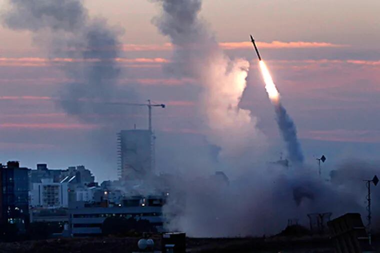 Israel's Iron Dome defense system is fired from the port town of Ashdod to intercept missiles from Gaza. Israel also authorized the activation of tens of thousands of reservists as it moved troops toward Gaza. TSAFRIR ABAYOV / AP