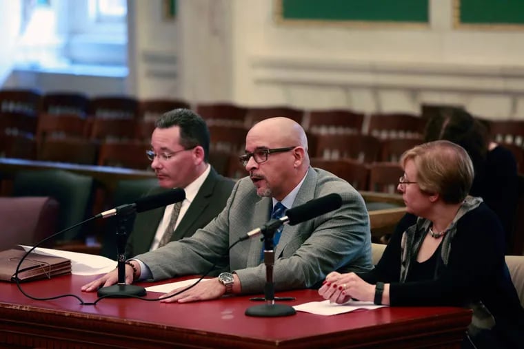 During a City Council Public Safety Committee hearing, Temple Hospital’s Scott Charles (center) testifies along with Philadelphia Police Capt. Francis Healy (left) and Shira Goodman of CeaseFirePA.