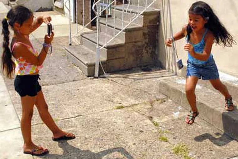 Elani Rodriquez, 5, is too quick for Centro Nueva Creaci&#0243;n classmate Siani Rodriquez, 6, to snap her picture. Children at the after-school and summer camp program look for good in the often-derided neighborhood. (Tom Gralish / Staff)