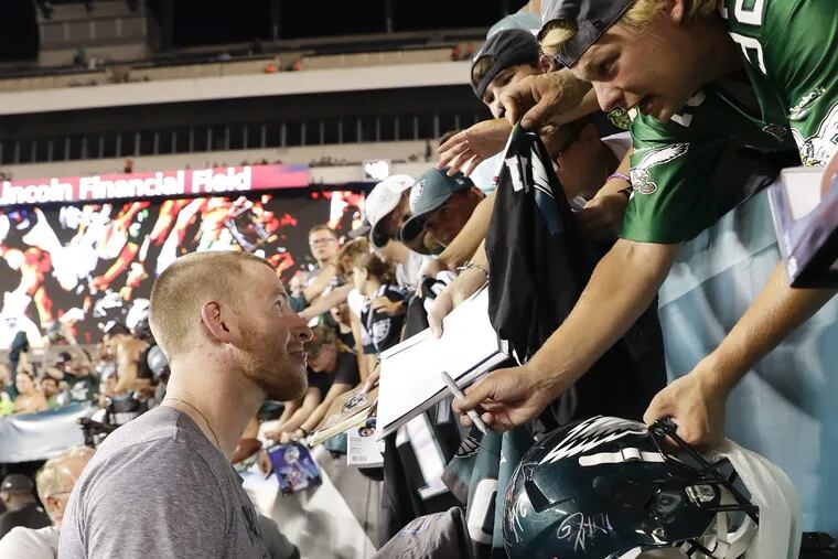 Eagles quarterback Carson Wentz signs his autograph for fans after the Eagles practiced at Lincoln Financial Field in South Philadelphia on Sunday, August 5, 2018. YONG KIM / Staff Photographer