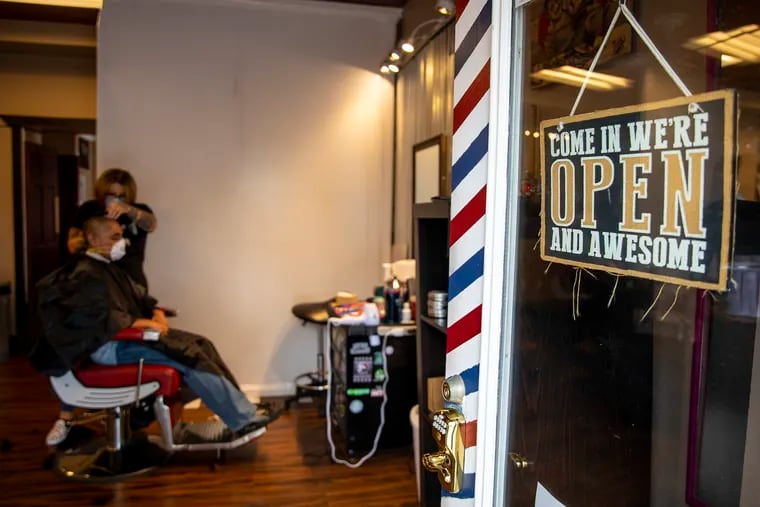 Nichole Missino, owner of Giovanni’s Media Barber Shop, has her door open for customers with appointments to get their haircut on Wednesday, May 20, 2020.  “The governor isn’t really giving us a choice,” Missino said. “I’m opening to save my business here. My employees need to eat, they need to pay the bills, and keep the roof over their head.”