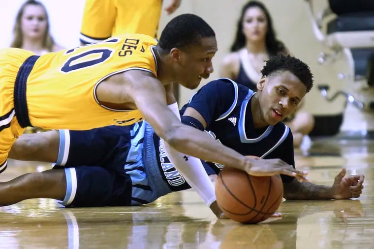 Guards Isiah Deas (left) of La Salle and Fatts Russell of Rhode Island battle on the floor for a loose ball in the second half.
