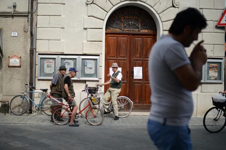A group of men talk on the main street in Luzzara, Italy on June 26, 2014. ( DAVID MAIALETTI / Staff Photographer )