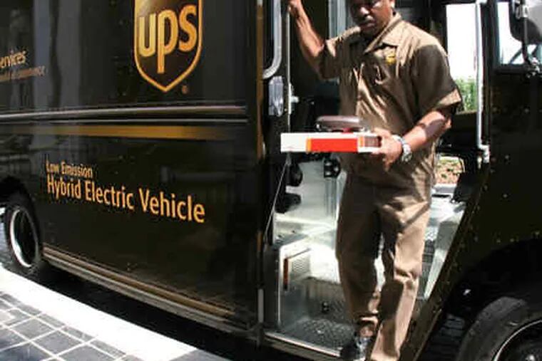 A UPS worker exits one of the company's hybrid diesel/electric delivery trucks, many of whichwill be used in Philadelphia.