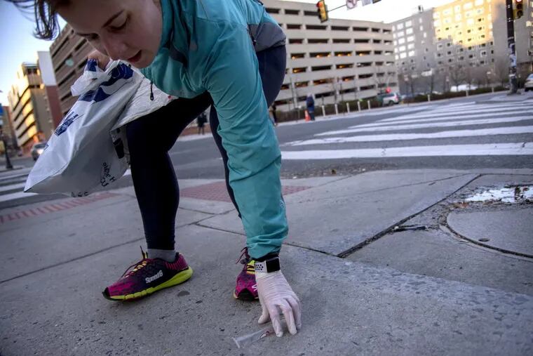 Aleks Cocic stops at 34th &amp; Chestnut Streets to pick up a piece of trash, as she runs with the West Philly Runners, along with the Clean Air Council and Not in Philly trying out plogging.