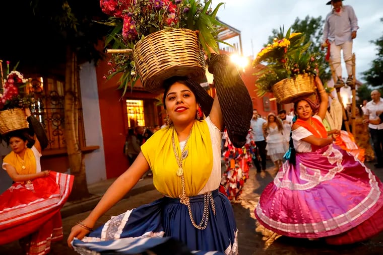 In   Oaxaca, Mexico, dancers in jewel-tone gowns, each balancing a basket of roses on her head, were part of a "calenda" (parade) celebrating a milestone through the historic center of the city.