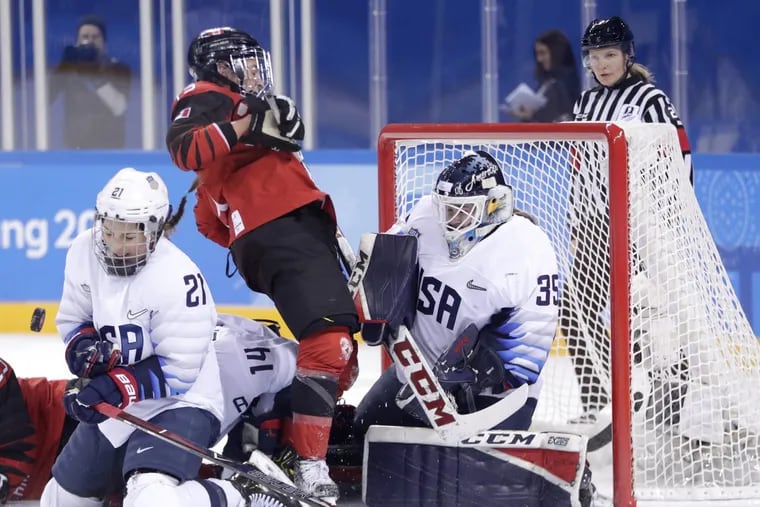 Hilary Knight, left, of the United States, blocks a shot by Canada as teammate goalie goalie Maddie Rooney, right, protects her net against Melodie Daoust during the first period of a preliminary round game at the 2018 Winter Olympics. Canada won the game, 2-1.