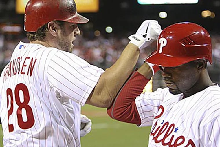 Kevin Frandsen celebrates his solo homer with teammate Jimmy Rollins against the Braves. (Steven M. Falk/Staff Photographer)